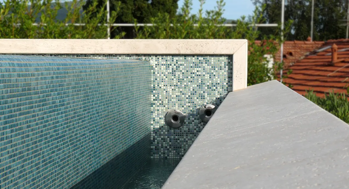 Dettaglio piscina rivestita con piastrelle in mosaico.
